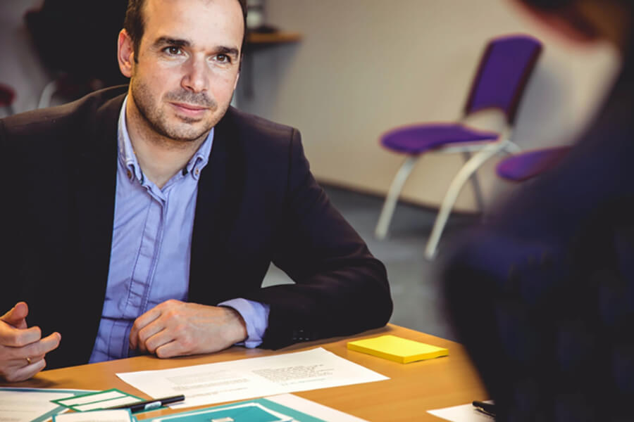 Over the shoulder image of man sitting at a table to discuss business 